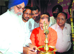 Chief Minister Parkash Singh Badal lights a candle at a function in Amritsar on Friday. 