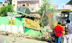 A mazaar being pulled down on the orders of the administration on the Hoshiarpur road in Jalandhar on Friday