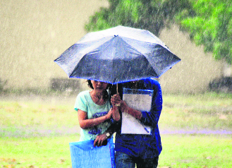 Students enjoy the pleasant weather during rain in Ludhiana on Friday