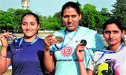 Discus gold winner Krishna Poonia flanked by Navjeet Kaur Dhillon and Manisha in Patiala on Friday