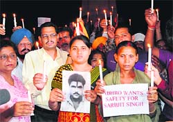 Praying for safety: Sukhpreet Kaur, wife of Indian prisoner in Pakistan Sarbjit Singh, and her daughter Swapandeep, take part in a candlelight march organised by the International Human Rights Organisation in Amritsar on Saturday. 