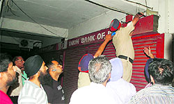 Police officials investigate after a bank siren went off on Friday in Mohali