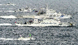 A Chinese marine surveillance ship Haijian No. 66 (C) cruises next to Japan Coast Guard patrol ships. 