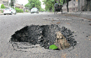A huge crater formed after a loaded truck crossed through a road in Master Tara Singh Nagar in Jalandhar on Saturday. The truck had to be taken out using a crane.