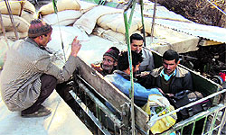 A private goods cable car carrying villagers sitting on ration sacks on the banks of the Chenab