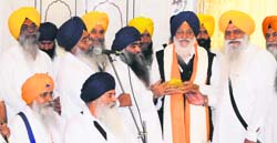 Damdami Taksal chief Harnam Singh Khalsa hands over Operation Bluestar Memorial keys to SGPC president Avtar Singh Makkar in Amritsar on Saturday.