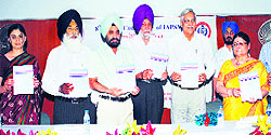 Doctors release a book at Sri Guru Ram Das Institute of Medical Sciences and Research during the annual conference of the Indian Association of Preventive and Social Medicine in Amritsar on Sunday