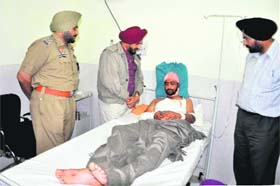 Inspector General of Police, Bathinda zone, Nirmal Singh Dhillon along with SSP Ravcharan Singh Brar (extreme left) and DIG Amar Singh Chahal enquire about the health of constable Mandeep Singh, who was injured by three undertrials before fleeing police custody, at the Civil Hospital in Bathinda