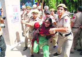 Policewomen rounding up a protester