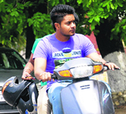 Students ride a two-wheeler without helmets on the PU campus.