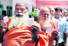 Saints line up at a polling station to cast their votes in the civic polls in Haridwar on Sunday. 