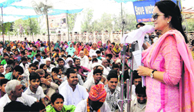 Public Health Engineering Minister Kiran Choudhry addresses a public meeting at Bapora village in Bhiwani on Sunday.