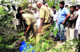Police personnel recover a woman's body packed in a bag from fields near Sakta Khera village in Sirsa.