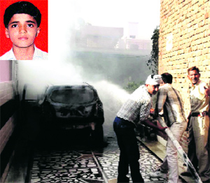 People try to save a car torched by protesters against the killing of a student (Inset) in Meham on Sunday.