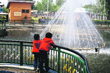 Two boys look at a fountain at a park in Srinagar on Sunday.