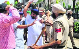 Policemen try to stop protesters in front of PWD Minister Sharanjit Singh Dhillon's residence in Ludhiana on Sunday
