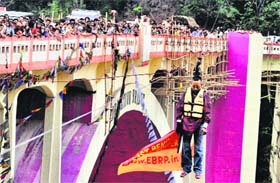 A daring feat gone awry: Sailendra Roy hangs on a ropeway by his ponytail during an event while crossing the Teesta through Coronation Bridge in Siliguri on Sunday
