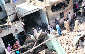People gather at a political party office a day after bomb attack in Karachi on Sunday
