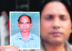 A man shows Rakesh's photograph