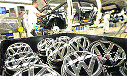 Emblems of VW Golf VII car are seen at a production line of German carmaker Volkswagen in Wolfsburg. The first-quarter profit at Volkswagen's core brand almost halved, Europe's biggest carmaker said on Monday, as manufacturers battle the region's protracted slump in demand with ever deeper discounts
