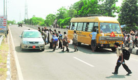  Students of Jainendra Public School cross the flyover on the Shimla-Zirakpur Highway.