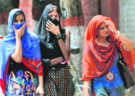 As the mercury rises, these girls try to keep away from the sun in Karnal.