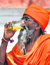 A holy man gulps down bale juice to beat the heat in Karnal. 