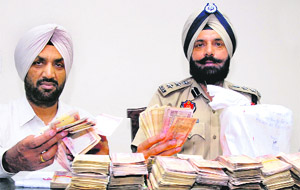 The SSP (Rural) Yurinder Singh Hayre and SP (D) Rajinder Singh show the recovered cash and heroin from a PO during a press conference in Jalandhar on Monday. 