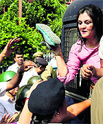 An activist shows her shoe to police personnel while being arrested after taking part in a protest against the chit fund scam in Kolkata on Monday