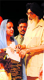 The widow of Naunidh Singh receivse his award from Chief Minister Prakash Singh Badal
