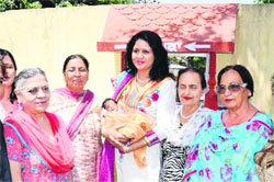 Members of the District Red Cross with the baby girl child received at 'Panghura' at Amritsar on Tuesday.