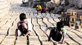 Children work with dexterity at a brick kiln on the outskirts of the city on Tuesday.