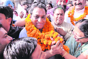 Winner Vinod Chamoli of the BJP being greeted by party workers in Dehradun on Tuesday.