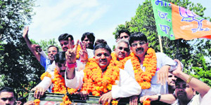 Manoj Garg of the BJP, along with MLAs Madan Kaushik and Aadesh Chauhan, takes out a victory procession in Haridwar on Tuesday.