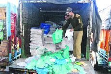Officials of the Commercial Taxes Department look at polythene bags seized at Qazigund checkpoint in Kulgam district on Tuesday.