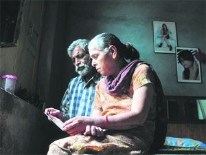The parents of the eight-year-old boy, who was murdered 16 years ago, look at their sons picture in Ludhiana. 