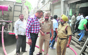 Fire brigade officials outside a shop at Mata Rani Chowk in Ludhiana on Tuesday.