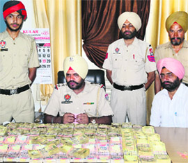 Police officials show ~75 lakh seized from an NRI couple in Ludhiana. 