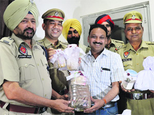 ADCP- III Joginder Singh hands over cash and ornaments to Rakesh Jain in Ludhiana on Tuesday. 
