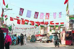 Flags and posters of political parties dot a Quetta street.