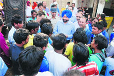 Civil Judge Kawaljit Singh (centre in blue turban) interacts with workers at a May Day seminar held to create awareness among labourers at Uria Colony on Wednesday.