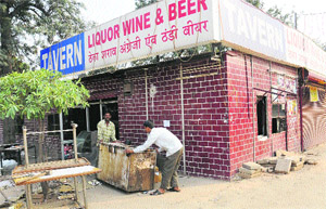 Employees of a contrator remove a temporary wine shop at the Industrial Area, Phase II, Chandigarh, on Wednesday. 