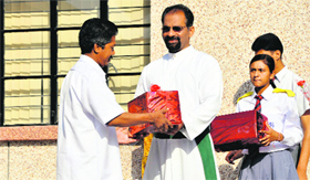 Brother George, Principal of St Joseph's Academy, honours staff members on May Day.