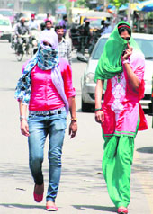 Girls cover their faces to protect themselves from the scorching heat in Jalandhar on Wednesday.