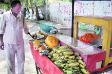 A vendor sells uncovered cut fruits in Jalandhar on Wednesday.