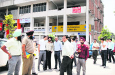 Residents come out of their offices after tremors were felt in Jalandhar on Wednesday afternoon. 