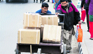 A man helps a labourer in pushing a handcart on a road in Srinagar on the International Labour Day (May Day) on Wednesday. 