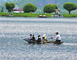 Students row a boat in the Dal Lake.