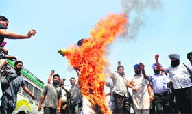 Members of Punjab roadways and PUNBUS Workers Union burn the effigy of the Transport Minister, Ajit Singh Kohar, in Ludhiana on Wednesday.