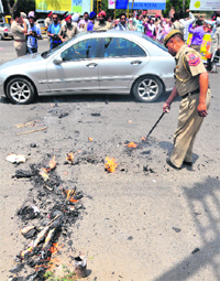 A policeman tires to douse flames after Congress leader Sajjan Kumars effigy was burnt by Youth Akali Dal workers outside the Mini-Secretariat in Ludhiana on Wednesday.